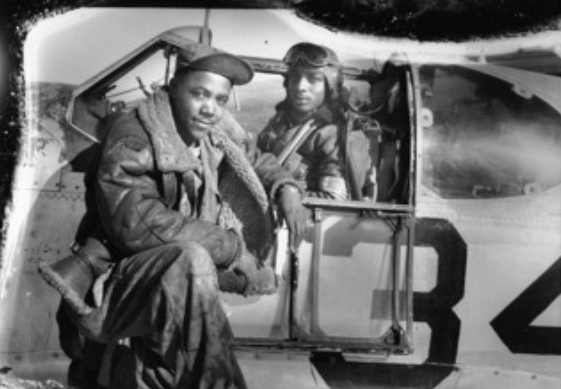 Thomas Hawkins seated in the plane he named for his wife, Gloria, with another airman beside the cockpit